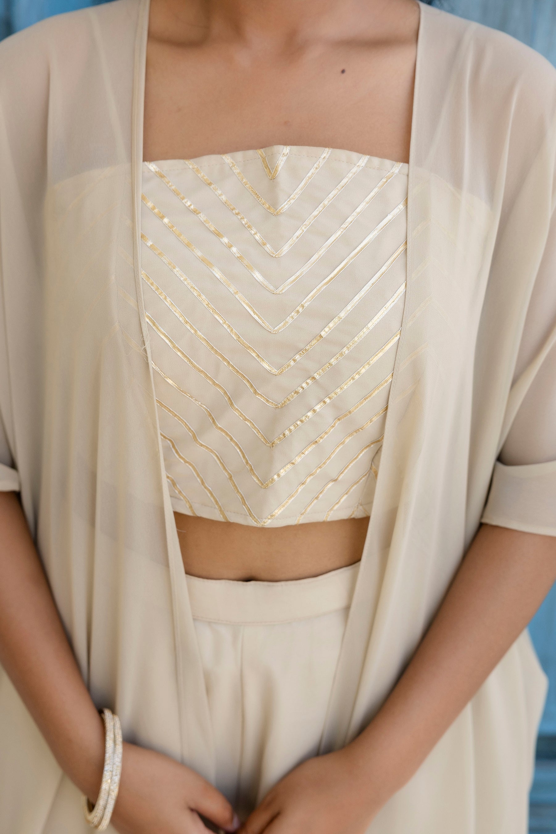 Glow in style with this ready-to-wear georgette ensemble featuring a graceful gotta patti work top, flowy palazzo, and a chic shrug
